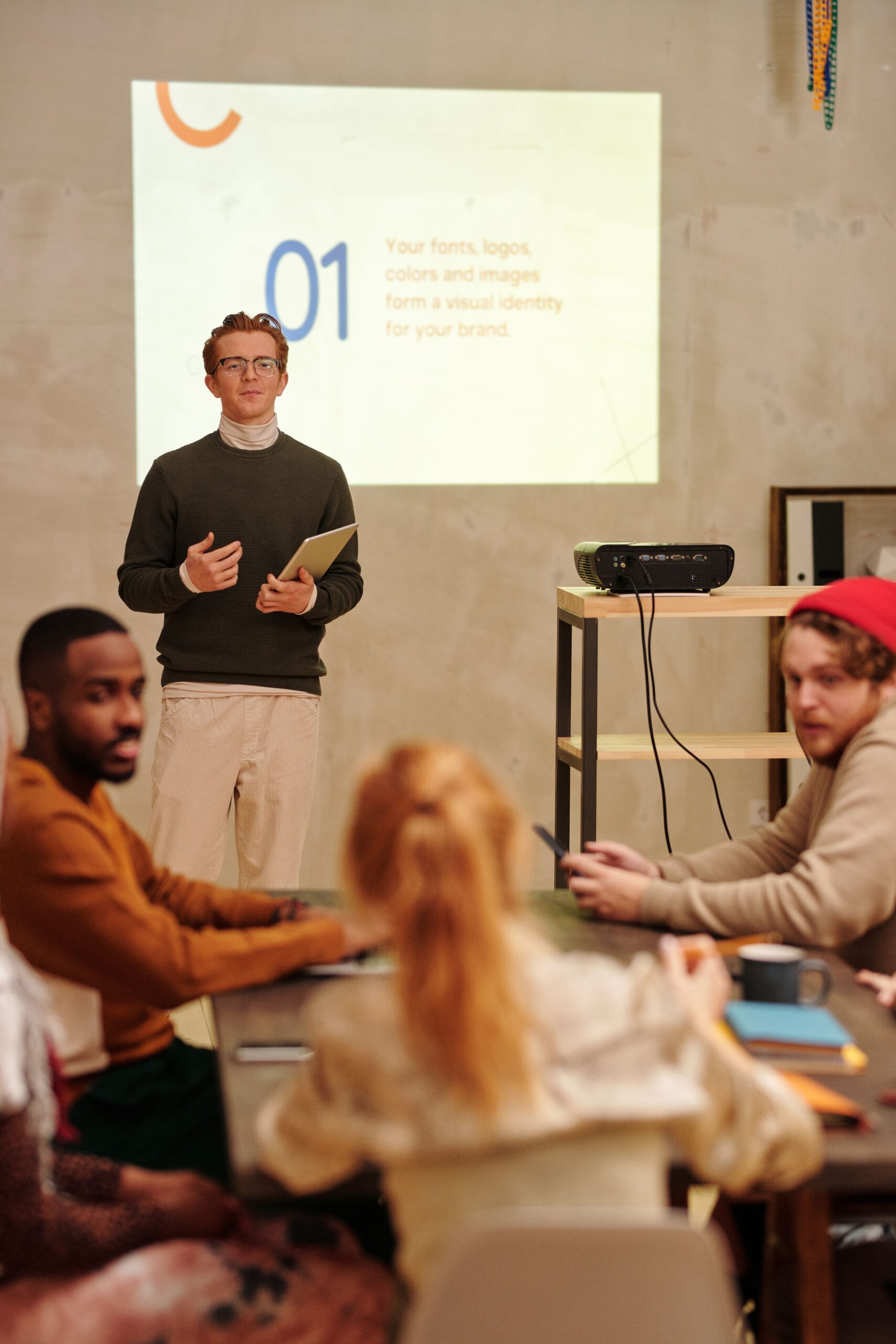 Formateur présentant un support projeté à un petit groupe de participants réunis autour d’une table